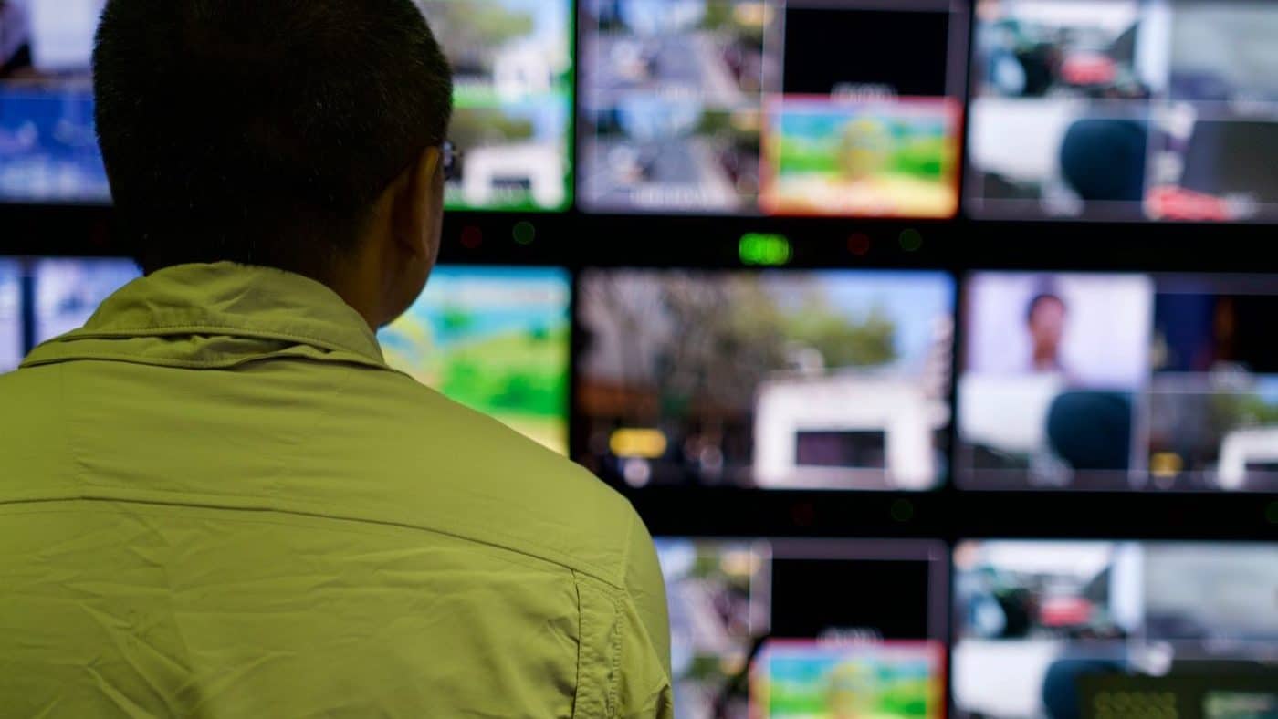 Operator watching a wall of monitors in a control room